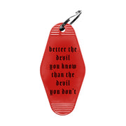 image of the back of a red diamond shaped keyring.  in black says better the devil you know than the devil you don't.